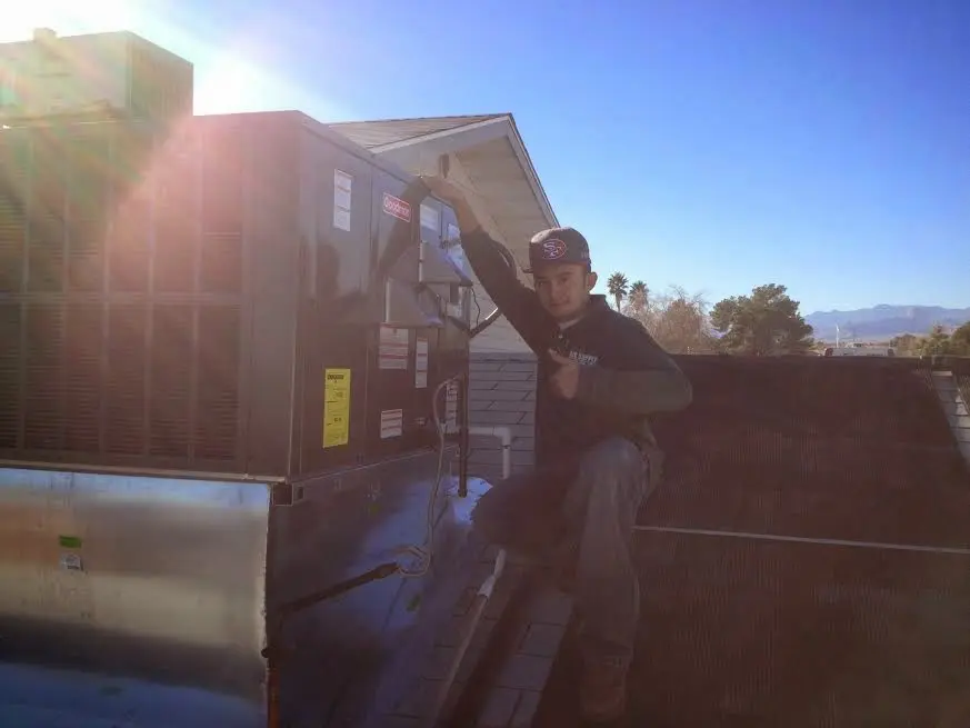 HVAC technician performing AC Tune-Up on a rooftop unit in Canterbury